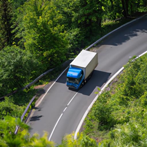 Xe tải vận chuyển hàng hóa chạy trên con đường núi quanh co, bao phủ bởi rừng xanh um tùm.