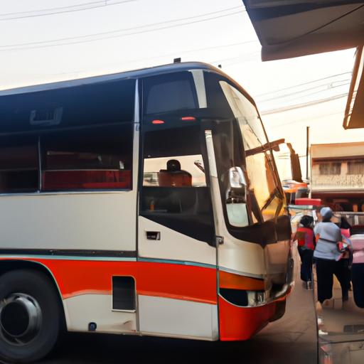 Xe khách Phong Phú đỗ trước trạm xe bận rộn với hành khách lên xe.